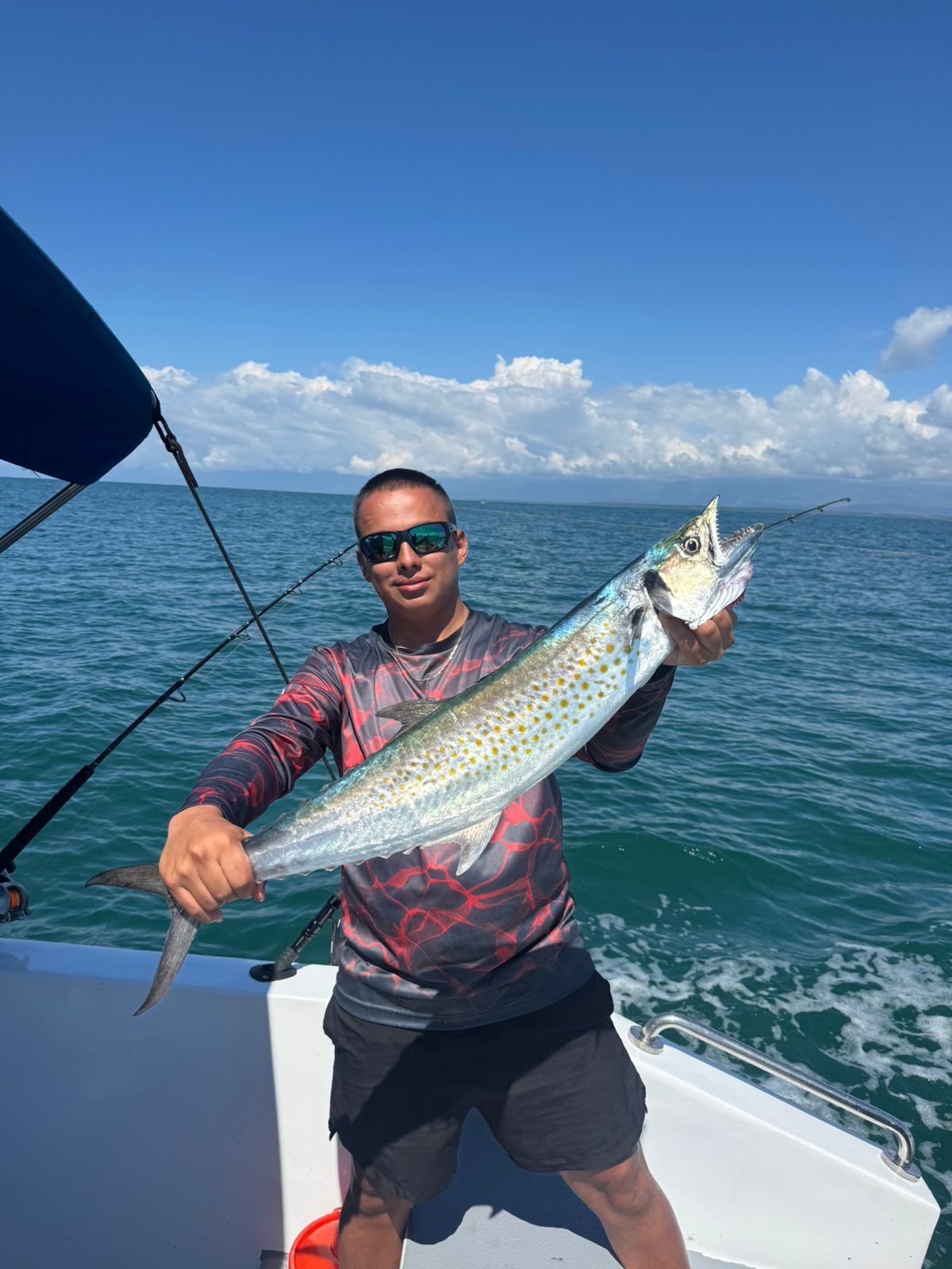 Guest holding a Spanish mackerel during a fishing tour from Uvita
